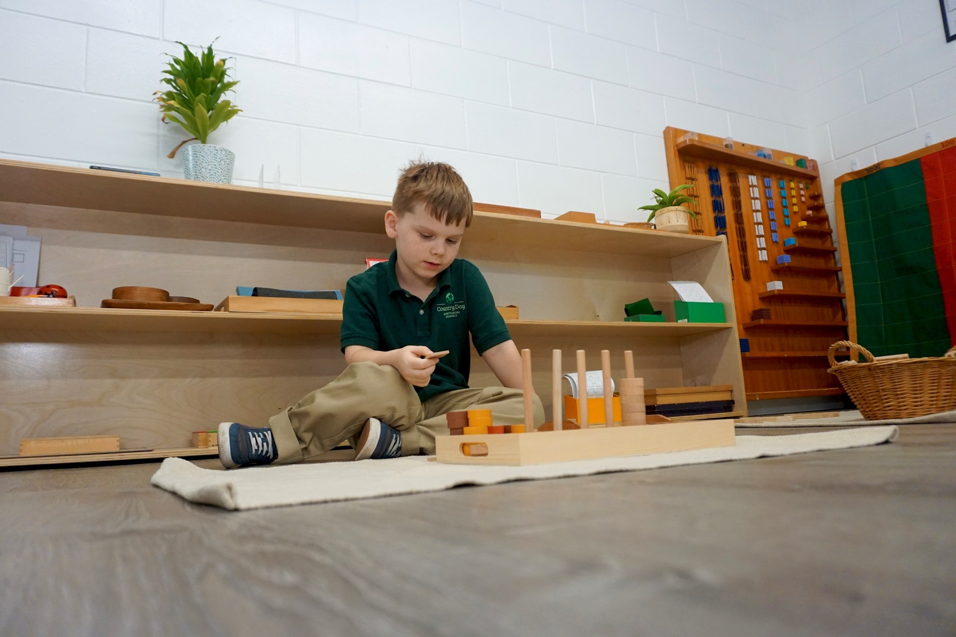 Montessori primary classroom with children engaging in hands-on activities using Montessori materials.