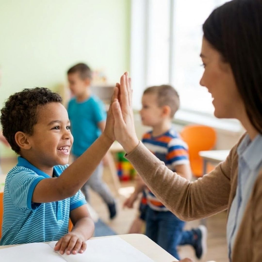 Child high-fiving teacher in classroom
